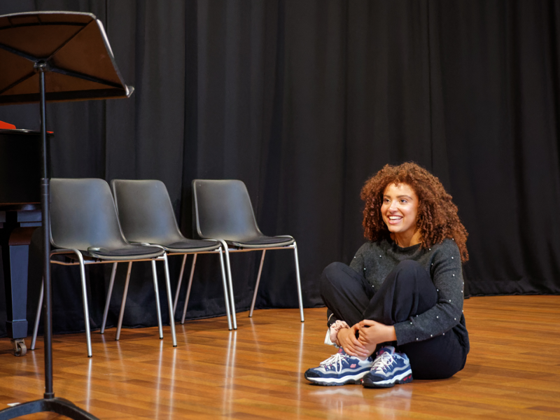 Person sat on the floor cross legged smiling