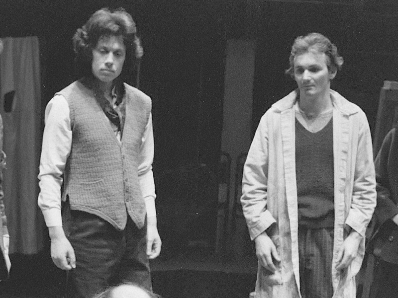 black and white photograph of four people stood in a line on stage