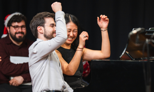 Two repetiteurs perform and smile in front of a black backdrop in a Wandsworth Wednesday Lunchtime Recital